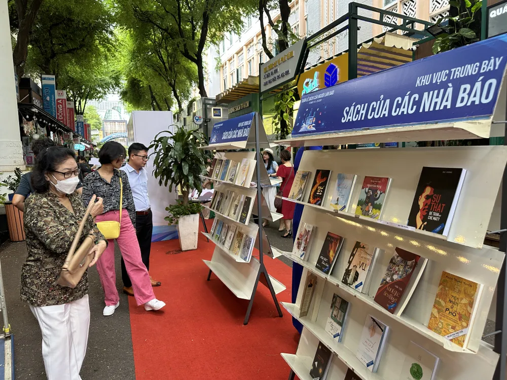 Du khách và bạn đọc xem các ấn phẩm do các nhà báo viết đang được trưng bày tại Đường sách TPHCM