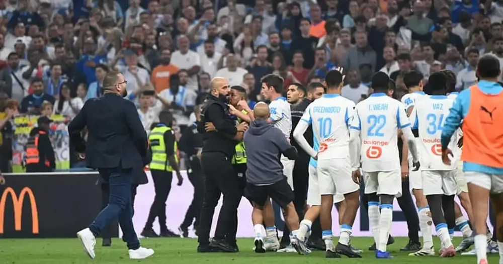Các cầu thủ Marseille ngăn cản xô xát giữa nhân viên an ninh sân Velodrome và Lucas Beraldo phía PSG. Ảnh: RMC Sport