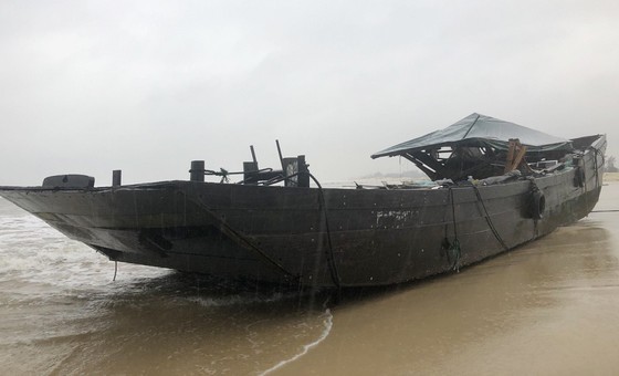 A wooden boat drifts ashore in Quang Tri Province. (Photo: SGGP)