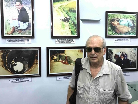 Mr. Ronald L. Haeberle and his photos of the Son My massacre at the Son My Memorial Site. (Photo courtesy of Mr. Ronald L. Haeberle)