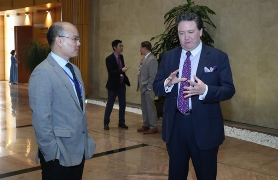 US Ambassador to Vietnam Marc E. Knapper discusses with Mr. Le Chi Dung, Head of the Americas Department of the Vietnamese Ministry of Foreign Affairs, at VIP A lobby before the welcome ceremony. (Photo: SGGP)