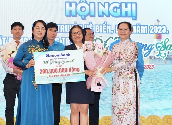 Mrs. Nguyen Thi Le, Chairwoman of the People's Council of HCMC, and Ms. Tran Kim Yen, Chairwoman of the Vietnam Fatherland Front Committee of HCMC, present flowers to thank units for contributing to the " For a Green Truong Sa" program. (Photo: SGGP)