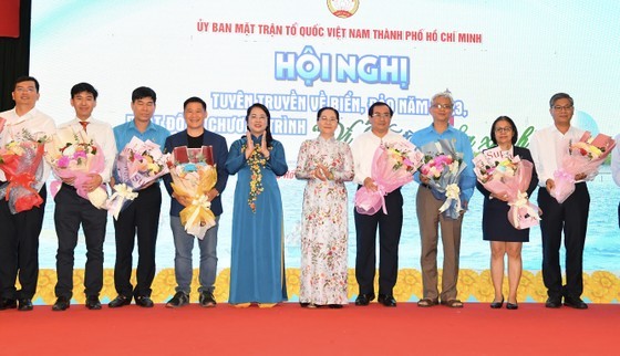 Mrs. Nguyen Thi Le, Chairwoman of the People's Council of HCMC, and Ms. Tran Kim Yen, Chairwoman of the Vietnam Fatherland Front Committee of HCMC, present flowers to thank units for contributing to the "Green Truong Sa" program. (Photo: SGGP)