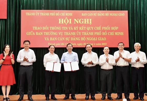 Minister of Foreign Affairs Bui Thanh Son and Chairman of the People's Committee of HCMC Phan Van Mai exchange coordination regulations.