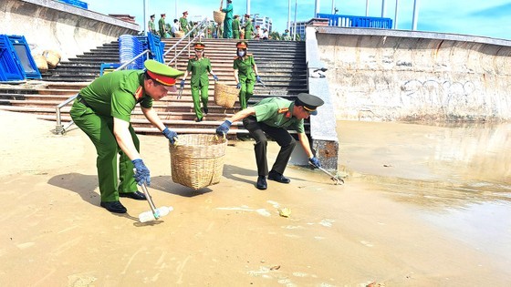 Police officers employ baskets made from environmentally friendly materials to gather trash on Ba Ria - Vung Tau Beach.