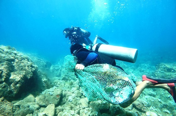 Divers at Nhon Hai coral island in Quy Nhon City, Binh Dinh Province, collect trash from the ocean floor.