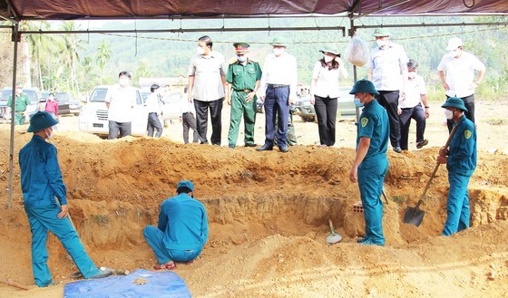 Authorities excavate and search for remains of fallen soldiers at the first burial pit.