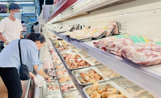 Customers buy meat at MM Mega Market in District 12