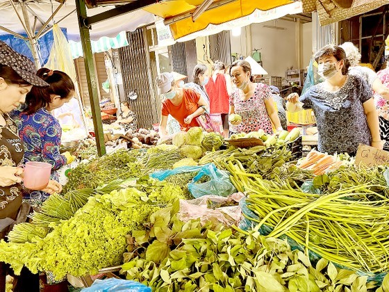 Customers buy vegetables at Ban Co Market in District 3