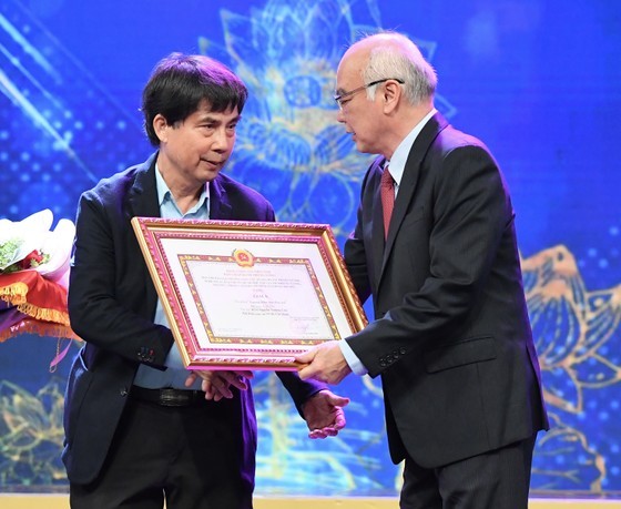 Mr. Phan Nguyen Nhu Khue, Head of the Propaganda and Education Board of the HCMC Party Committee, presents the A prize to Architect Nguyen Truong Luu.