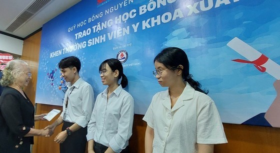 Dr. Truong Thi Xuan Lieu, Chairwoman of the Board of Trustees of the Nguyen Van Huong Scholarship Fund, presents scholarships to outstanding medical students at the event.