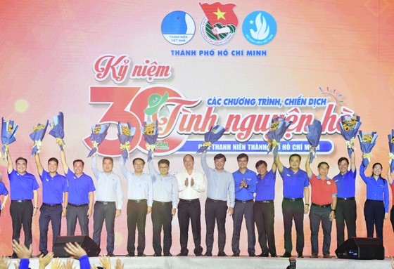 Deputy Secretary of HCMC Party’s Committee Nguyen Ho Hai and First Secretary of HCYU Central Committee Bui Quang Huy are delivering flowers to Heads of the Steering Committees of summer volunteer campaigns through periods (Photo: SGGP)