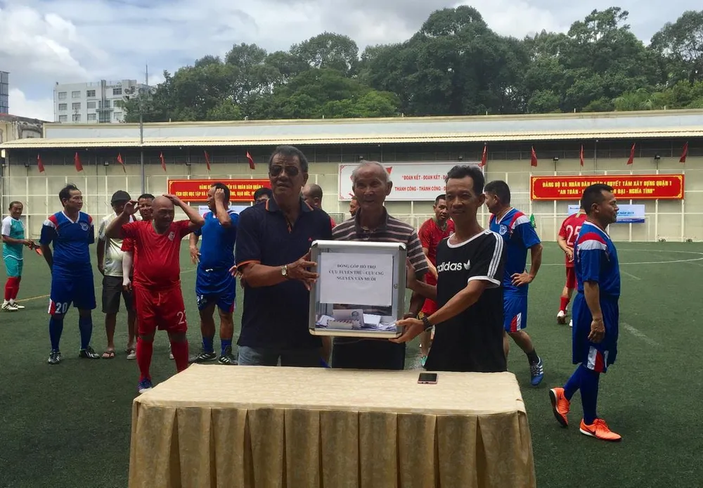 Hai cựu cầu thủ Lưu Kim Hoàng và Lê Văn Tư chuyển tiên hỗ trợ đến gia đình cựu cầu thủ Nguyễn Văn Mười. Ảnh: Anh Trần