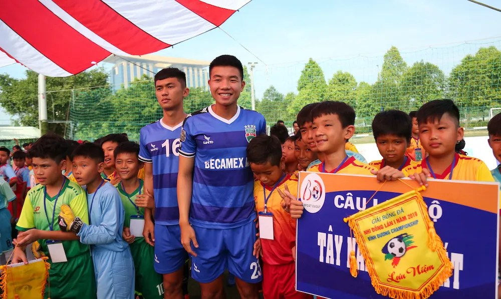 Các cầu thủ CLB B.Bình Dương đến giao lưu cùng các em nhỏ ở ngày khai mạc. Ảnh: Anh Trần