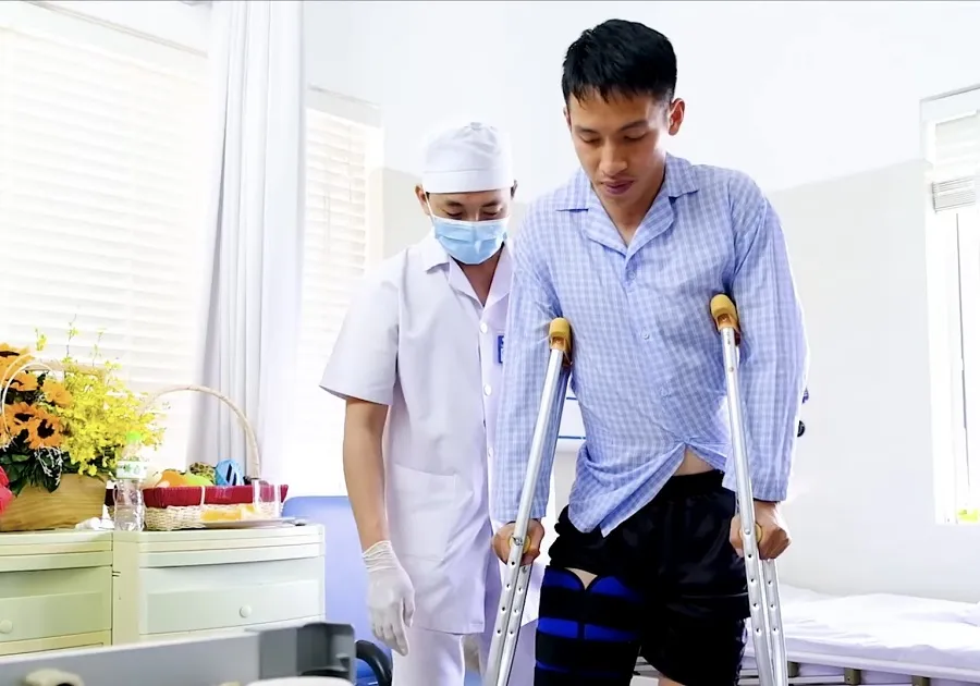 Hùng Dũng được bác sĩ dìu đi sau phẫu thuật