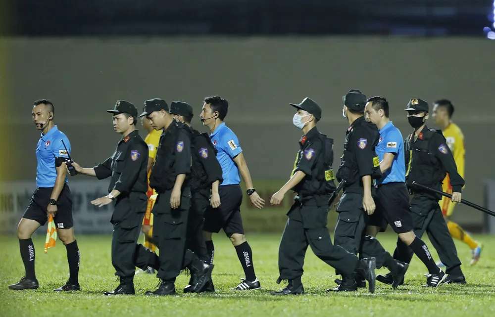 Lực lượng CSCĐ phải vào sân bảo vệ tổ trọng tài từ những phản ứng của cầu thủ CLB TPHCM. Ảnh: THANH ĐÌNH