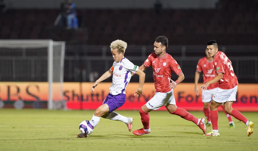 Văn Vũ nỗ lực đi bóng trước sự đeo bám của hậu vệ CLB TPHCM. Ảnh: DŨNG PHƯƠNG