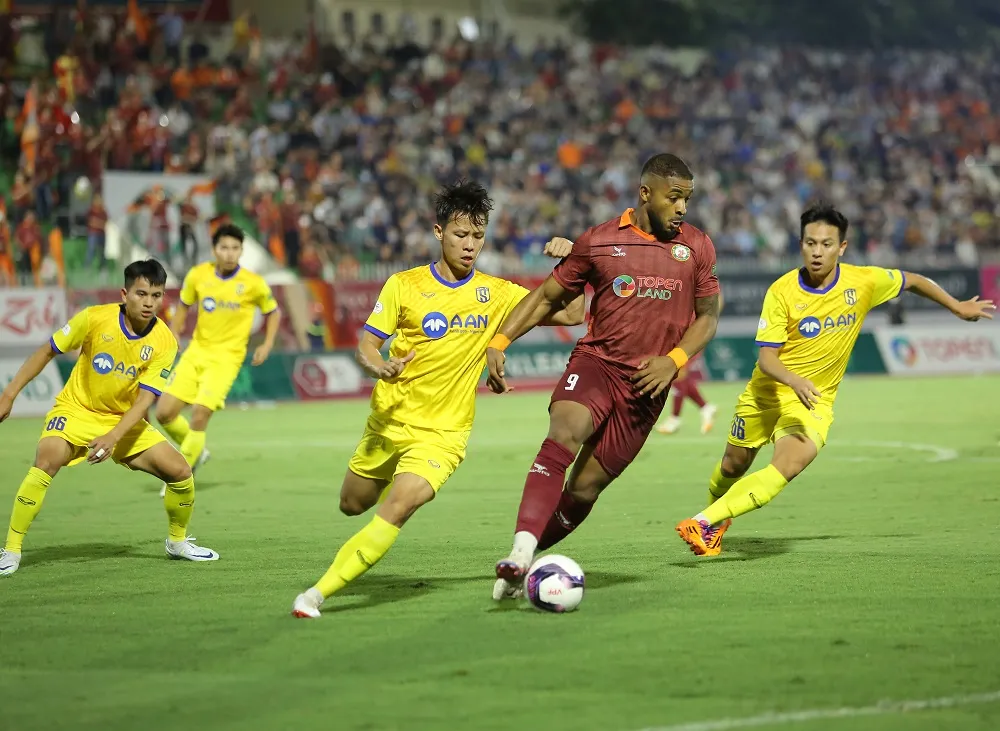 Hendrio đi bóng trước sự bám đuổi của các hậu vệ SLNA