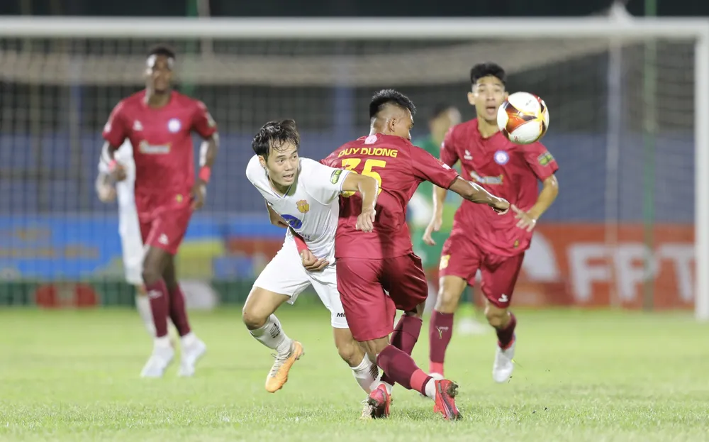 Văn Toàn nỗ lực thoát qua sự kèm cặp của hậu vệ Khánh Hòa. Ảnh: DŨNG PHƯƠNG
