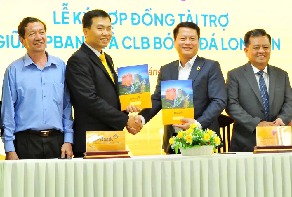 Ông Nguyễn Minh Tâm, Giám đốc Công ty CP Thể thao Long An (thứ hai từ phải sang) bắt tay cùng ông Phạm Ngọc Thủy, Giám đốc LPBank chi nhánh Long An tại lễ ký hợp đồng. Ảnh: ANH TUẤN 