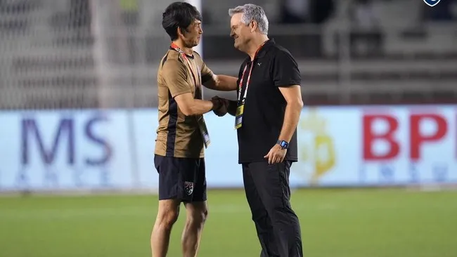 HLV Ishii (bên trái) cùng đồng nghiệp Capellas trao đổi sau trận đấu. Ảnh: FAT