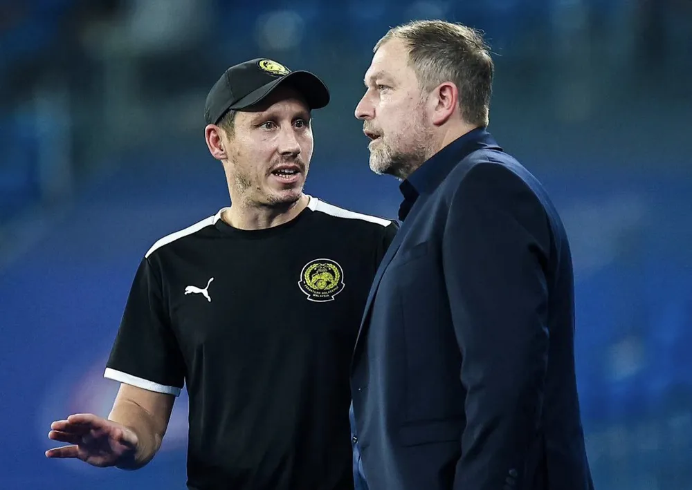 Trợ lý huấn luyện viên Mark Milligan (bên trái).