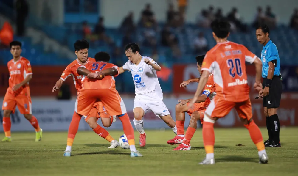 Văn Toàn giữa vòng vây của các hậu vệ Đà Nẵng. 