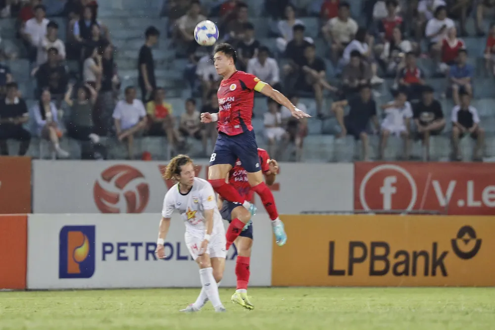 Bùi Hoàng Việt Anh bật cao phá bóng trước nỗ lực tranh chấp của Viktor Le. Ảnh: MINH HOÀNG