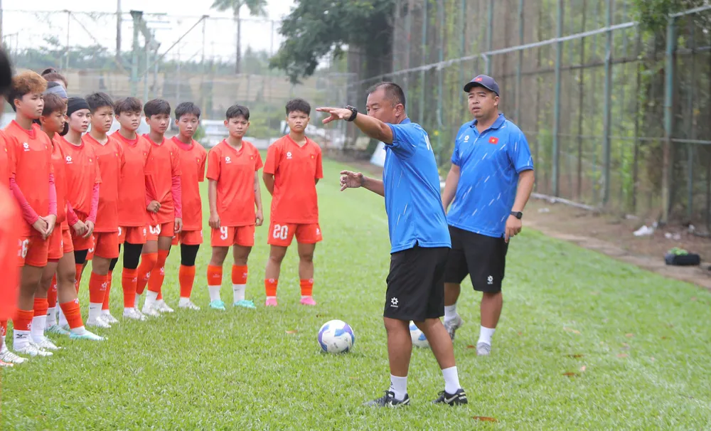 HLV Okiyama Masahiko cùng các học trò trên sân tập ngày 23-5.