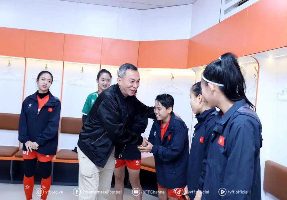 Ông Trần Quốc Tuấn bắt tay động viên Ngân Thị Vạn Sự cùng các tuyển thủ nữ Việt Nam tại buổi gặp.
