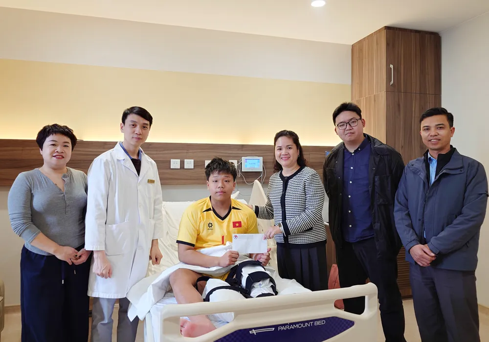 Bà Nguyễn Thanh Hà (thứ 3 từ trái sang) thay mặt lãnh đạo VFF đến thăm cầu thủ Đoàn Tuấn Phong tại bệnh viện sau khi phẫu thuật thành công.