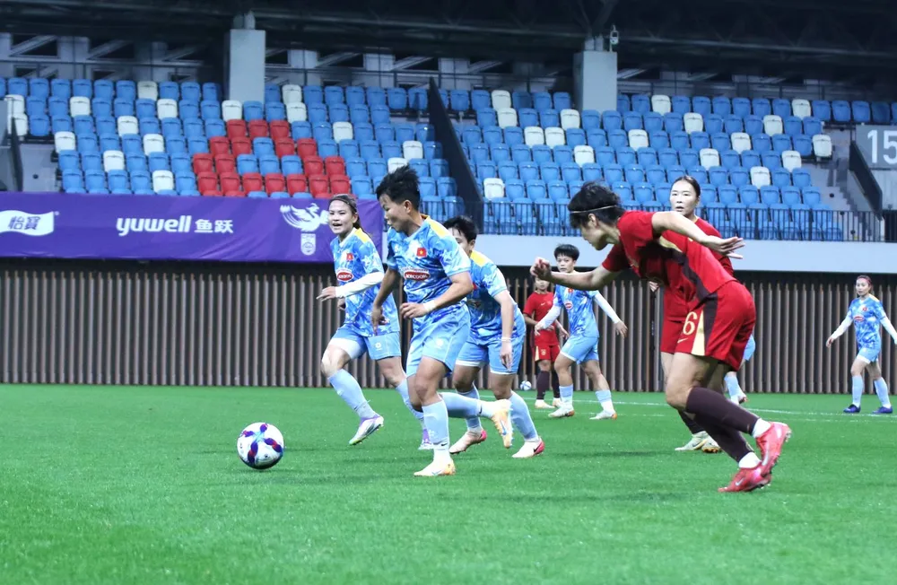 Bích Thùy đi bóng trước sự bám sát của hậu vệ đội tuyển nữ Trung Quốc.