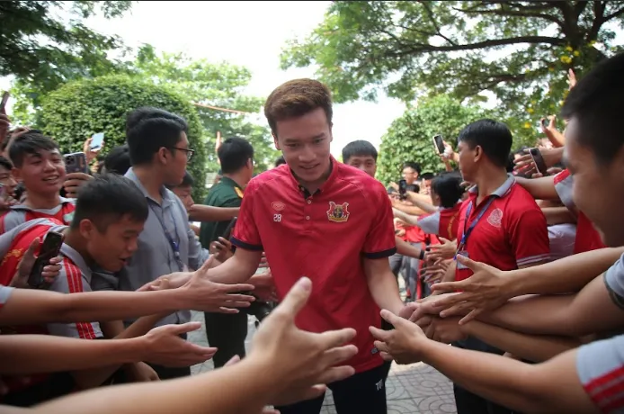 Các bạn trẻ chào đón Hoàng Đức cùng những thành viên của CLB Ninh Bình từ sân trường. Ảnh: DŨNG PHƯƠNG