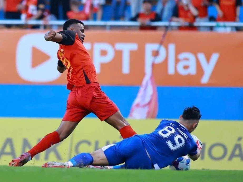 Thủ môn Lê Giang Patrick nỗ lực bắt bóng trong chân của Gustavo (Ninh Bình). Ảnh: NBFC