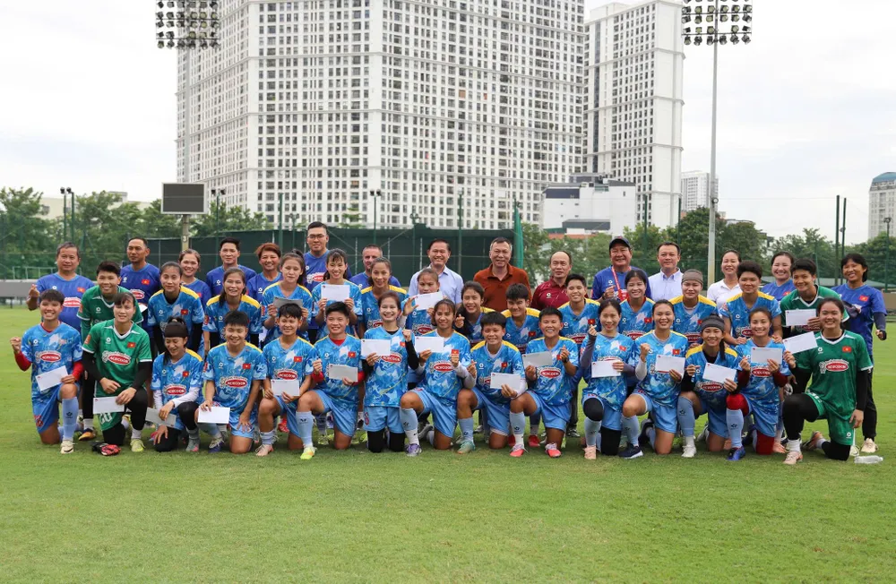 Lãnh đạo VFF chụp hình lưu niệm cùng đội tuyển nữ Việt Nam trên sân tập ngày 31-8. Ảnh: ĐOÀN NHẬT