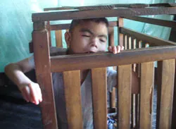 Cậu bé hơn 10 năm sống trong cũi