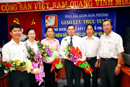 Phó TBT Hoàng Văn Kháng (bìa phải) tặng hoa Phó GĐ Sở Xây dựng Đỗ Phi Hùng cùng các cán bộ của Sở. Ảnh Việt Dũng