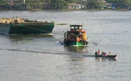 Một chiếc đò ngang chở khách đang cố vượt qua trước mũi sà lan để cập bến rất dễ gây tai nạn (ảnh chụp tại bến đò An Lợi Đông)