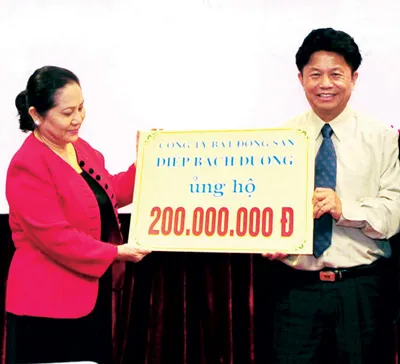 Bà Dương Thị Bạch Diệp trao tiền ủng hộ cuộc thi cho Tổng biên tập Báo SGGP Trần Thế Tuyển. Ảnh: MINH ĐIỀN