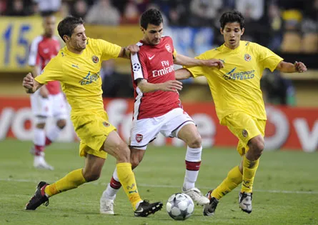 Tiền vệ Cesc Fabregas (giữa) đi bóng trong vòng vây của các hậu vệ Villarreal.