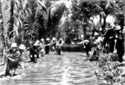 Dân công hỏa tuyến chuyển khẩu đội pháo hạng nặng qua đoạn bùn lầy Cà Mau. Ảnh: VÕ AN KHÁNH (st)