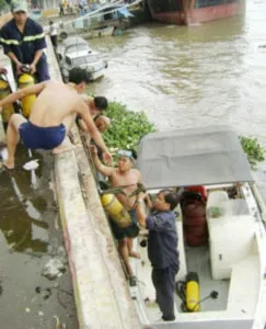 Đội cứu hộ - Sở Cảnh sát PCCC TPHCM - đang chuyển khí tài, thiết bị để lặn mò xác nạn nhân một vụ chìm tàu trên sông Sài Gòn. Ảnh: Đ.H.