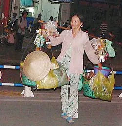 Chị Phan Thị Hoa Thơm nặng gánh trên vai rảo bước