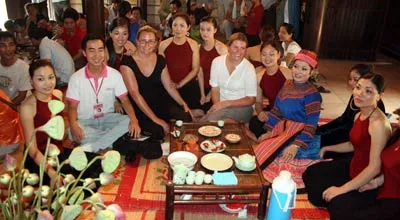 Những cô gái trong trang phục yếm thắm chụp ảnh chung cùng du khách tại chiếu trà.