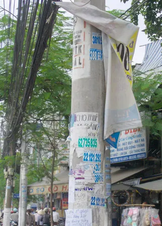 Quảng cáo “phất phơ” trên cột điện (ảnh chụp trên đường Lý Thường Kiệt, sáng nay, 15-6). Ảnh: H.V.