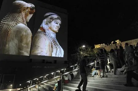 Người dân Athen và du khách xem hình chiếu các bức tượng điêu khắc cổ đại Hy Lạp trước lối vào viện bảo tàng.