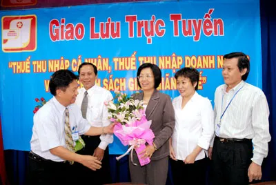 Tổng biên tập báo SGGP Trần Thế Tuyển tặng hoa các cán bộ Cục Thuế TPHCM sau buổi giao lưu.