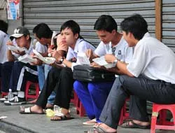 Thí sinh dự thi vào Trường cao đẳng Nguyễn Tất Thành được phát cơm miễn phí sau buổi thi môn Văn. Ảnh : Mai Hải.