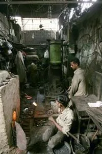 Công nhân đang đúc các dụng cụ bằng sắt tại một lò luyện kim thủ công ở Karachi. Ảnh AP