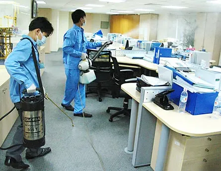 Phun thuốc khử trùng tại công sở có người nghi mắc cúm A/H1N1. Ảnh: Tr.Thanh